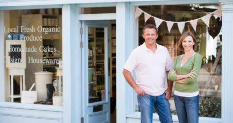 Couple standing in front of organic food store smiling