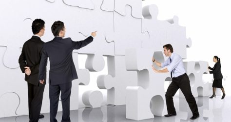 business teamwork - business men making a puzzle